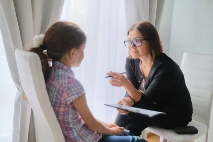 A woman engages in conversation with a young girl, sharing a moment of connection and understanding between them.